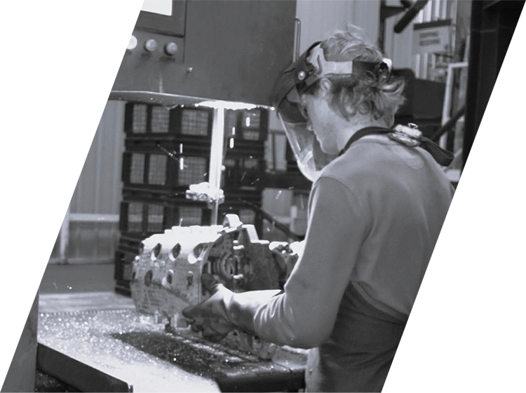 Foundry worker cutting an aluminum part using a machine tool at BRP Spruce Pine