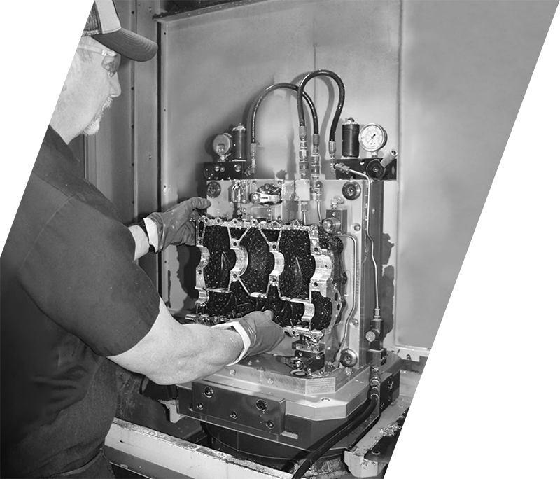 Technician handling an aluminum part on a precision machining tool at BRP Spruce Pine